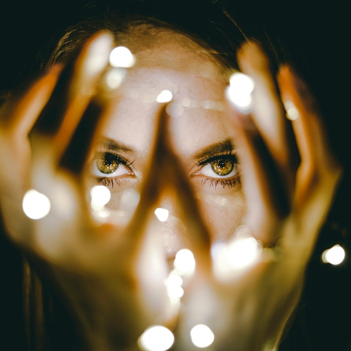 woman holding string lights