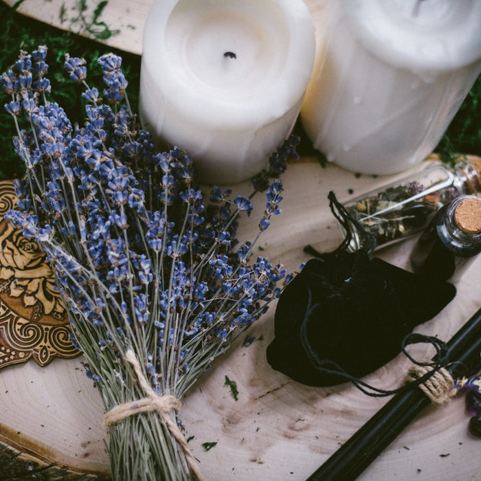 white pillar candle beside silver and black hair brush