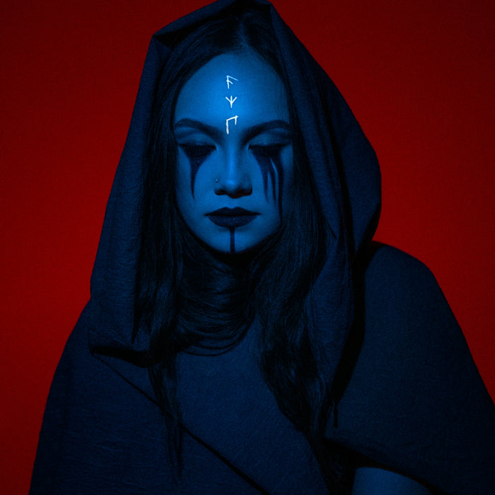 a woman with blue makeup and a hoodie with arrows painted on her face