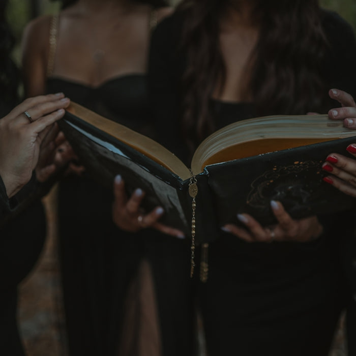 a group of women standing next to each other holding a book