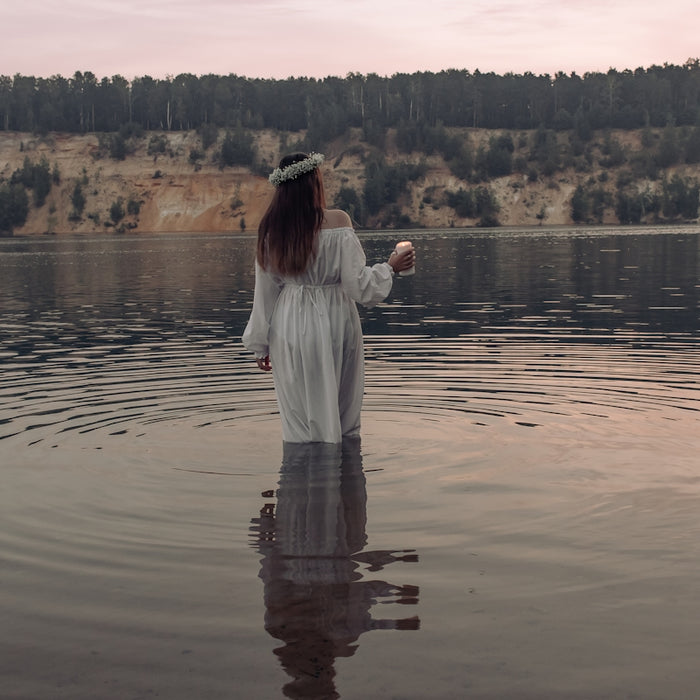 a person standing in a body of water with trees in the background