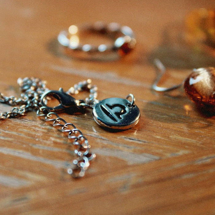 a wooden table topped with lots of different types of jewelry
