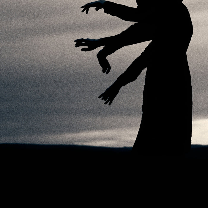 A silhouette of a person throwing a frisbee