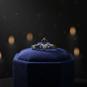 Silver ring on a blue cushion with a dark, blurred background