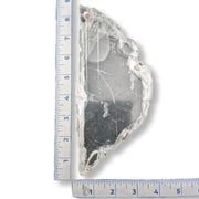 A raw, selenite plate shown next to a blue ruler for scale on a white background.