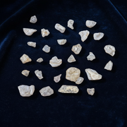 Collection of rough pink stones on a dark blue fabric background