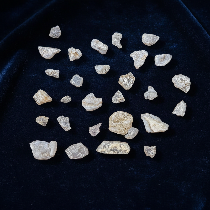 Collection of rough pink stones on a dark blue fabric background