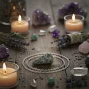 Wiccan or spiritual items including candles, stones, and a pendulum on a wooden surface.