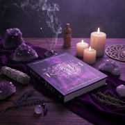 Book titled 'Mastery of Reiki' surrounded by candles, crystals, and smoldering incense on a dark surface.