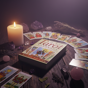 Tarot cards, book, and candle on a wooden surface with a dark background