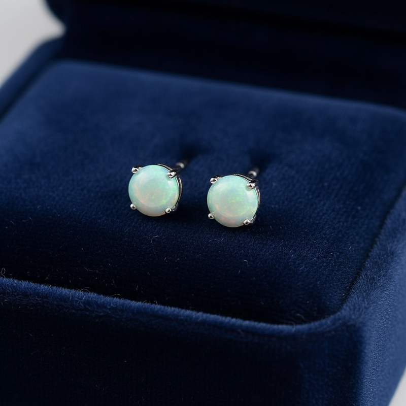 Pair of amazonite stud earrings on a blue velvet cushion