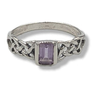 Silver ring with a purple gemstone on a white background