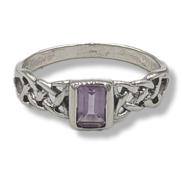 Silver ring with a purple gemstone on a white background