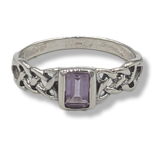 Silver ring with a purple gemstone on a white background