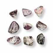 Nine polished tumbled gemstone chips in shades of purple, pink, white, and gray, arranged in a grid on a white background with soft drop shadows.