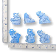Set of six blue elephant figurines on a white background with rulers for reference of size.