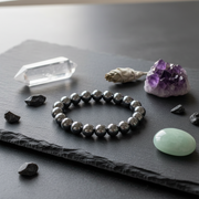 Silver beaded bracelet on a dark surface with crystals and stones