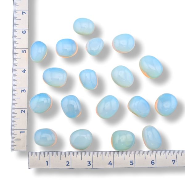 Set of light blue stones with a ruler for scale on a white background