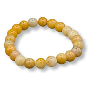 Beaded bracelet with yellow and beige beads on a white background