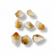 Nine raw citrine crystals on a white background