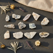 Pieces of agate geodes on a dark slate surface, decorated with dried lavender, flowers, and a linen cloth.