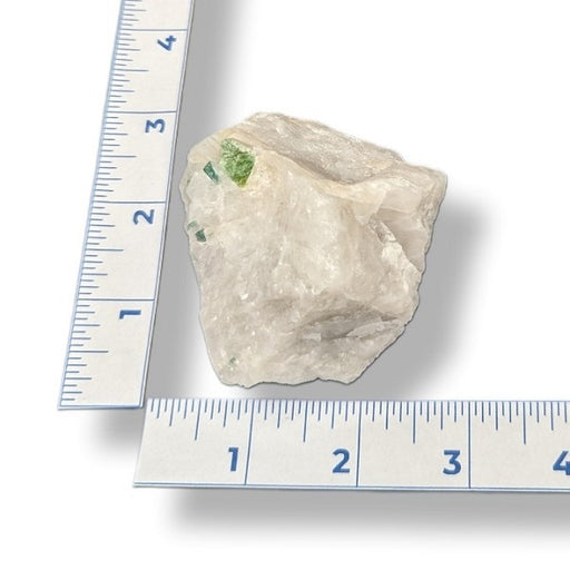 Rock next to a ruler on a white background