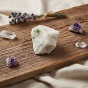 Mineral stone and crystals on a wooden surface with a bundle of lavender.