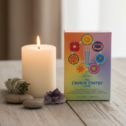 Chakra Energy Cards box with a lit candle and amethyst crystal on a wooden surface