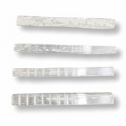 Four rectangular selenite rods arranged vertically on a white background, each showing natural striated texture and subtle color variation.