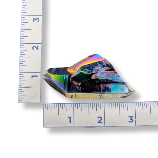 Colorful crystal next to a ruler on a white background
