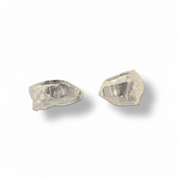 Two raw lemurian quartz on a white background