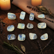 Set of yellow obsidian stones on a table with herbs and candles for ambiance.