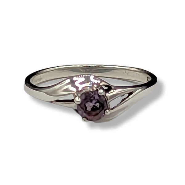 Silver ring with a purple gemstone on a white background