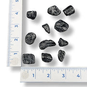Black stones on a white background with rulers for scale