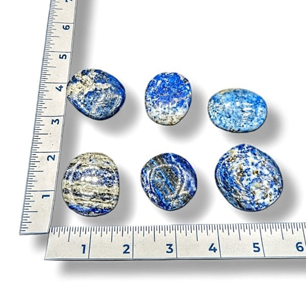 Blue and white marbled stones with a ruler for scale on a white background