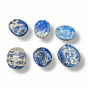 Set of six blue and white marbled stones on a white background