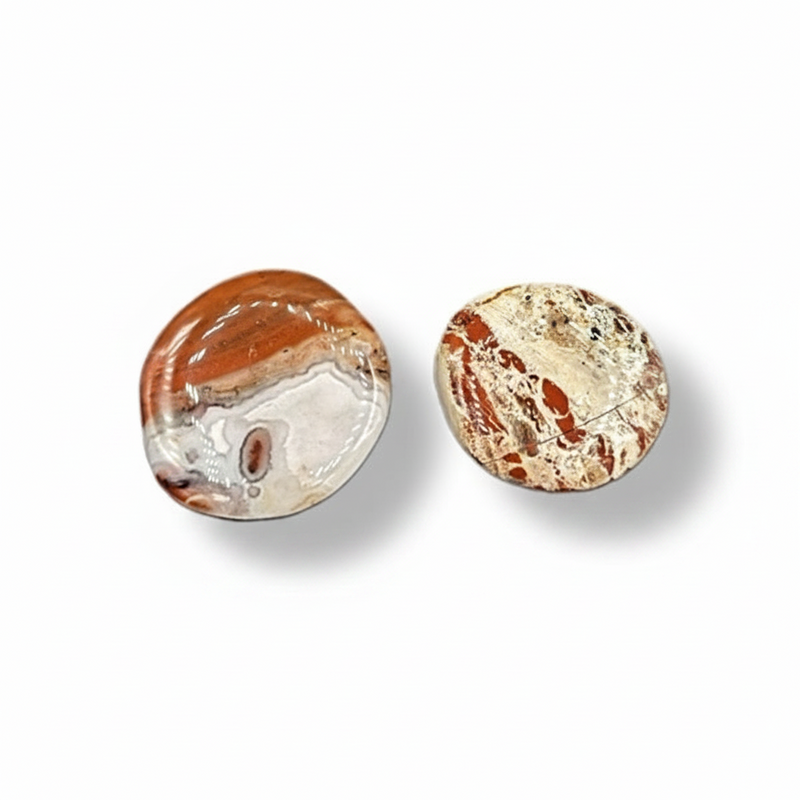 Two round, polished stones with a marbled pattern on a white background