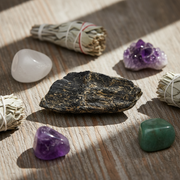 Collection of crystals and smudge sticks on a wooden surface