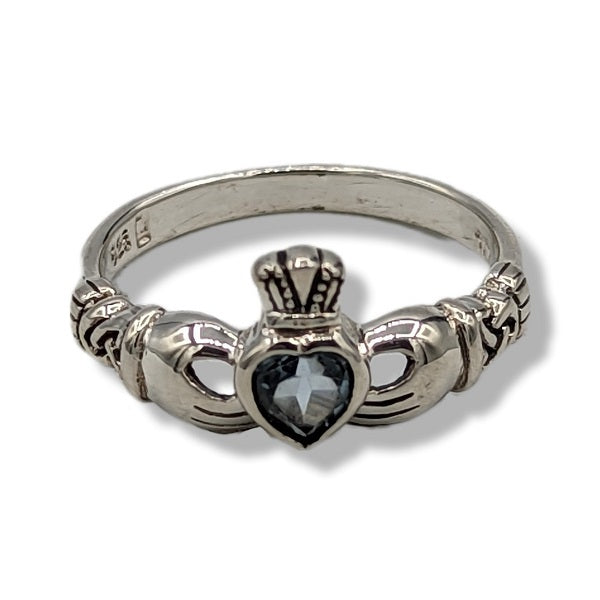 Silver claddagh ring with a heart-shaped stone on a white background