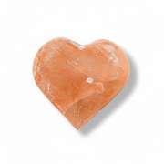A heart-shaped orange selenite with a natural crystalline texture, shown on a clean white background with a soft drop shadow.