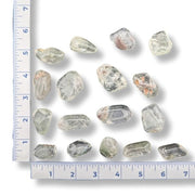 Collection of shamanic quartz  with a ruler for scale on a white background