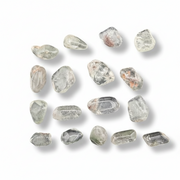 A set of small, irregular clear gemstones with natural inclusions and subtle gray, green, and brown tones, arranged on a plain white background with soft drop shadows.