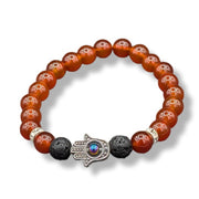 Bracelet with red beads, black lava rock beads, and a silver Hamsa hand charm on a white background