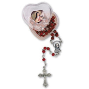 Red wood rosary with silver cross in a heart-shaped box on a white background