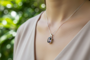 Silver pendant with a colorful gemstone on a white background