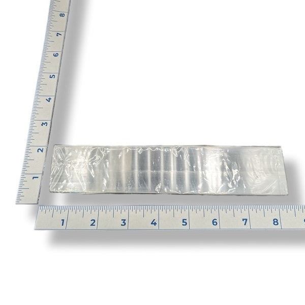 A selenite ruler 6-inches in length with a ruler for scale on a white background
