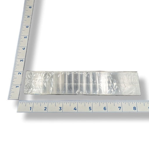 A selenite ruler 6-inches in length with a ruler for scale on a white background