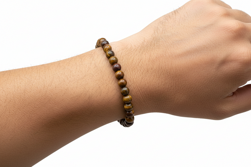 Hand wearing a beaded bracelet on a white background