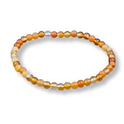 Beaded bracelet with orange, gold, and silver beads on a white background