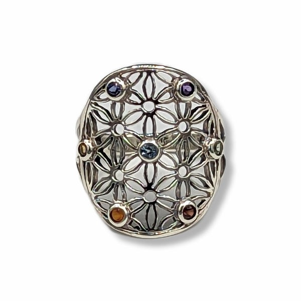 Silver ring with floral design and embedded gemstones on a white background